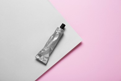 Photo of Tube of glue on color background, top view. Space for text