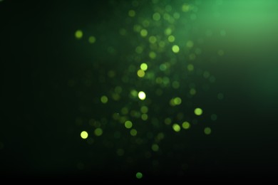 Photo of Blurred view of festive lights on green background. Bokeh effect