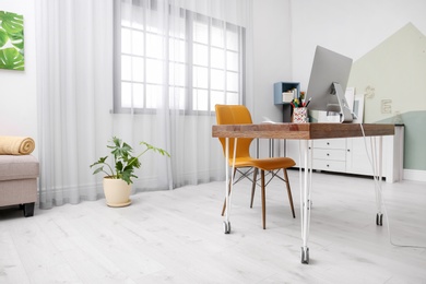 Photo of Comfortable workplace with computer on desk in home office
