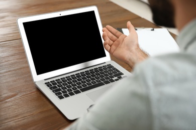 Photo of Man using video chat on laptop in home office, closeup. Space for text