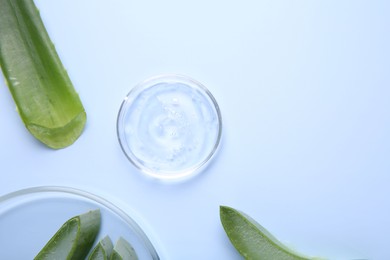 Photo of Aloe vera leaves and cosmetic gel on light blue background, top view. Space for text