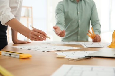 Photo of People working with construction drawings at table, closeup