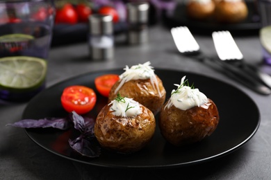 Photo of Delicious hot baked potato with sour cream dressing on grey table