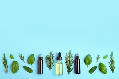 Photo of Flat lay composition with herbal essential oils and space for text on light blue background