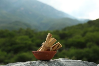 Photo of Many palo santo sticks on stone surface in high mountains