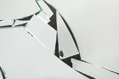 Photo of Shards of broken mirror on dark background, top view