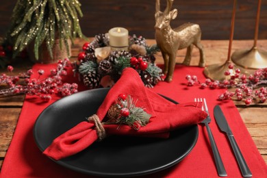 Photo of Festive place setting with beautiful dishware, cutlery and decor for Christmas dinner on wooden table