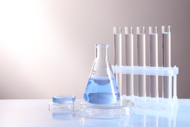 Photo of Laboratory analysis. Different glassware on table against light background, space for text