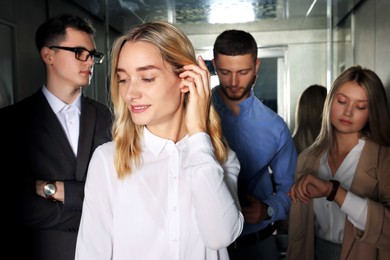 Photo of Group of office workers in modern elevator