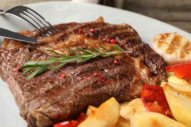 Photo of Delicious grilled beef steak and vegetables on plate, closeup