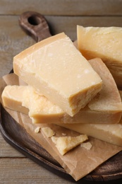 Photo of Pieces of parmesan cheese on wooden table, closeup