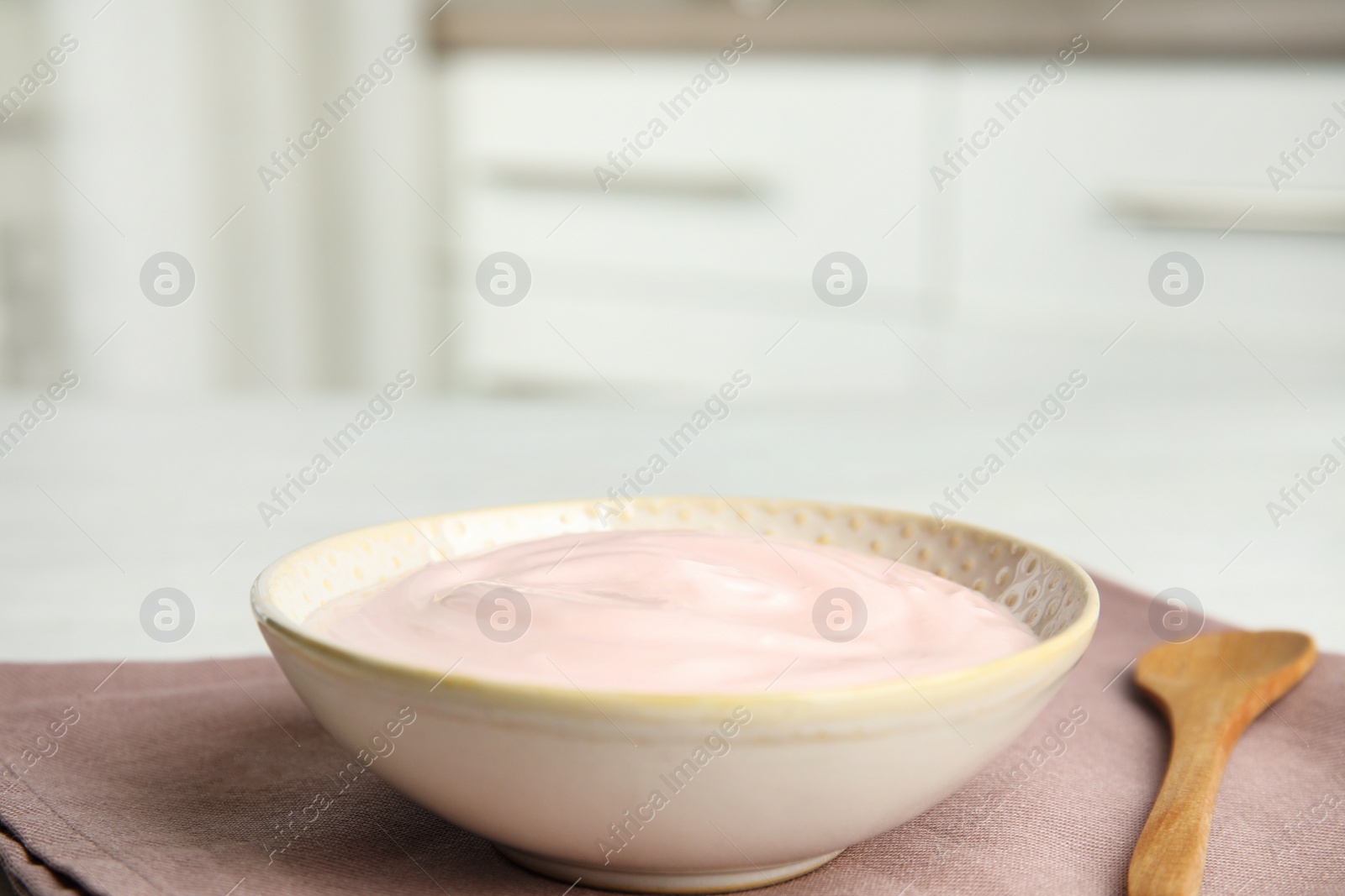 Photo of Tasty organic yogurt on fabric indoors. Space for text