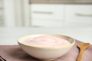 Photo of Tasty organic yogurt on fabric indoors. Space for text