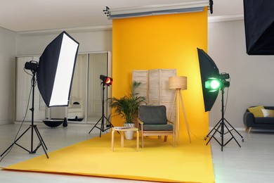Photo of Stylish furniture in photo studio with professional equipment