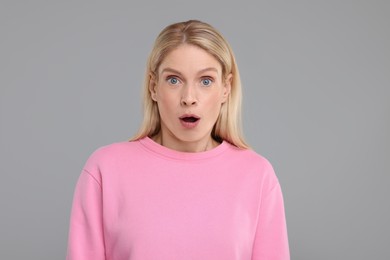Photo of Portrait of surprised woman on grey background