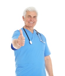 Photo of Portrait of male doctor in scrubs showing thumb up isolated on white. Medical staff