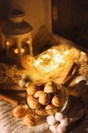 Photo of Delicious nut shaped cookies with boiled condensed milk and Christmas decor on knitted fabric