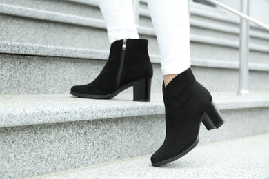Photo of Woman in stylish boots on stairs outdoors, closeup
