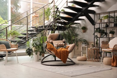 Photo of Indoor terrace interior with hanging chair and green plants