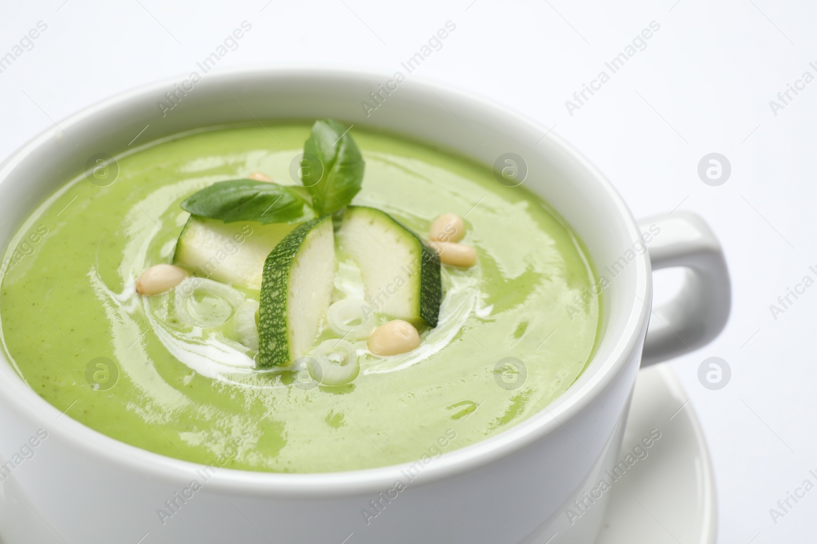 Photo of Tasty homemade zucchini cream soup isolated on white, closeup