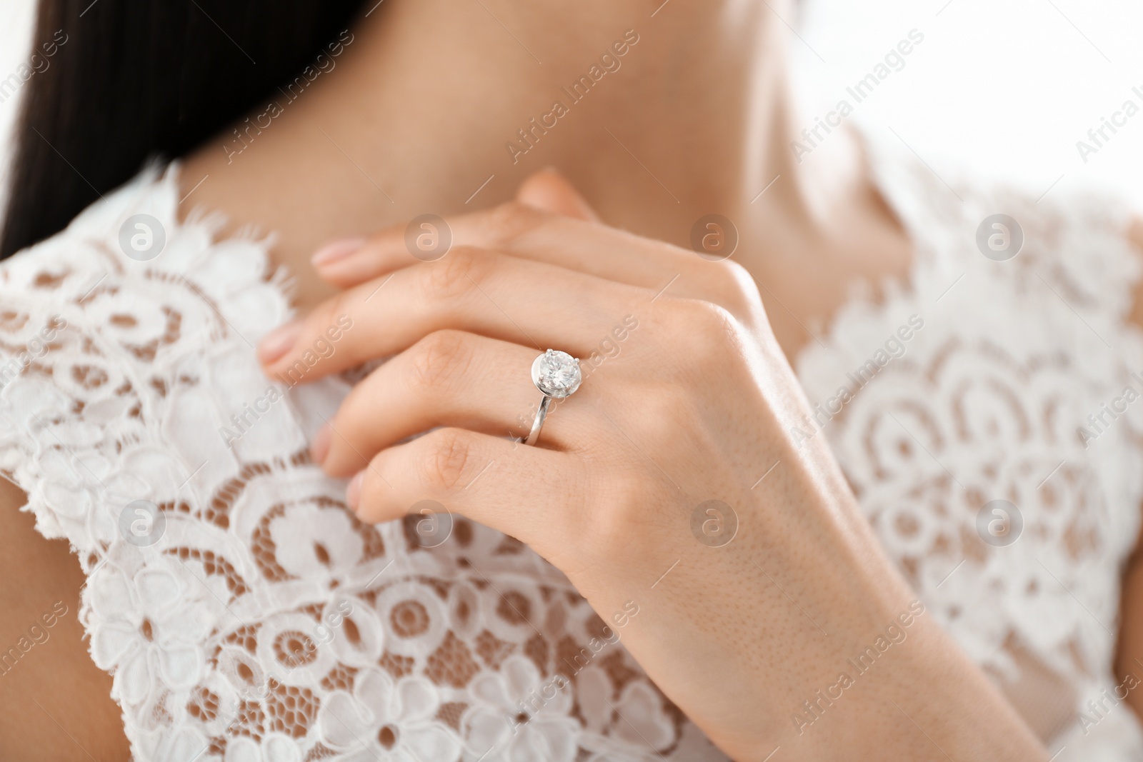 Photo of Young bride wearing beautiful engagement ring, closeup