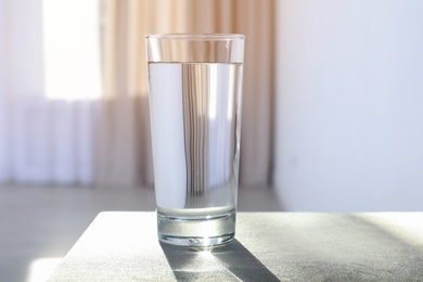 Glass of water on table against blurred background