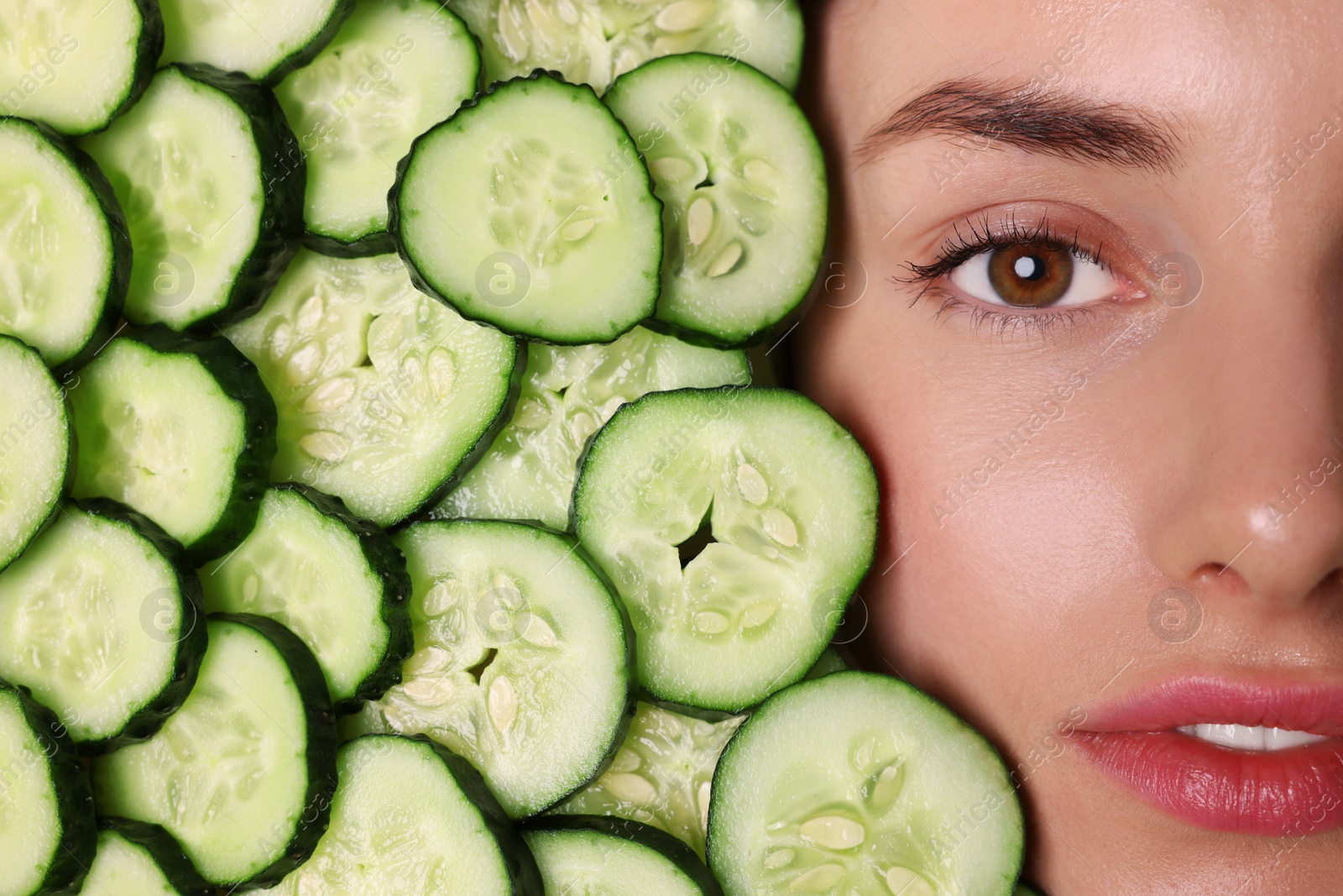 Photo of Beautiful woman among cucumber slices, top view