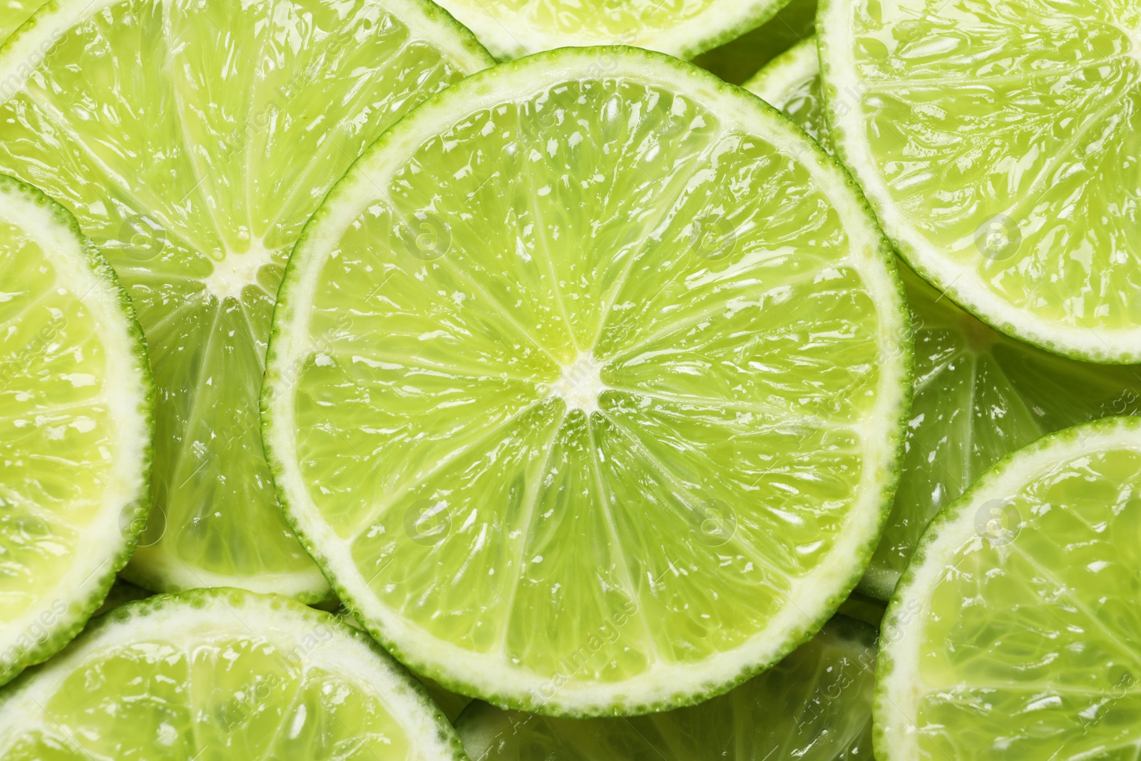 Photo of Fresh sliced ripe limes as background, top view