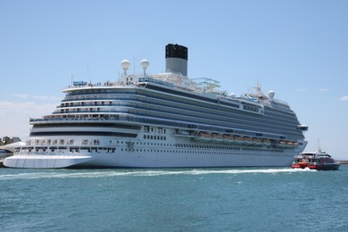 Photo of Modern cruise ship and boat in sea on sunny day