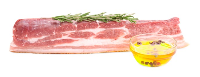 Photo of Piece of raw pork belly, rosemary and oil with spices isolated on white