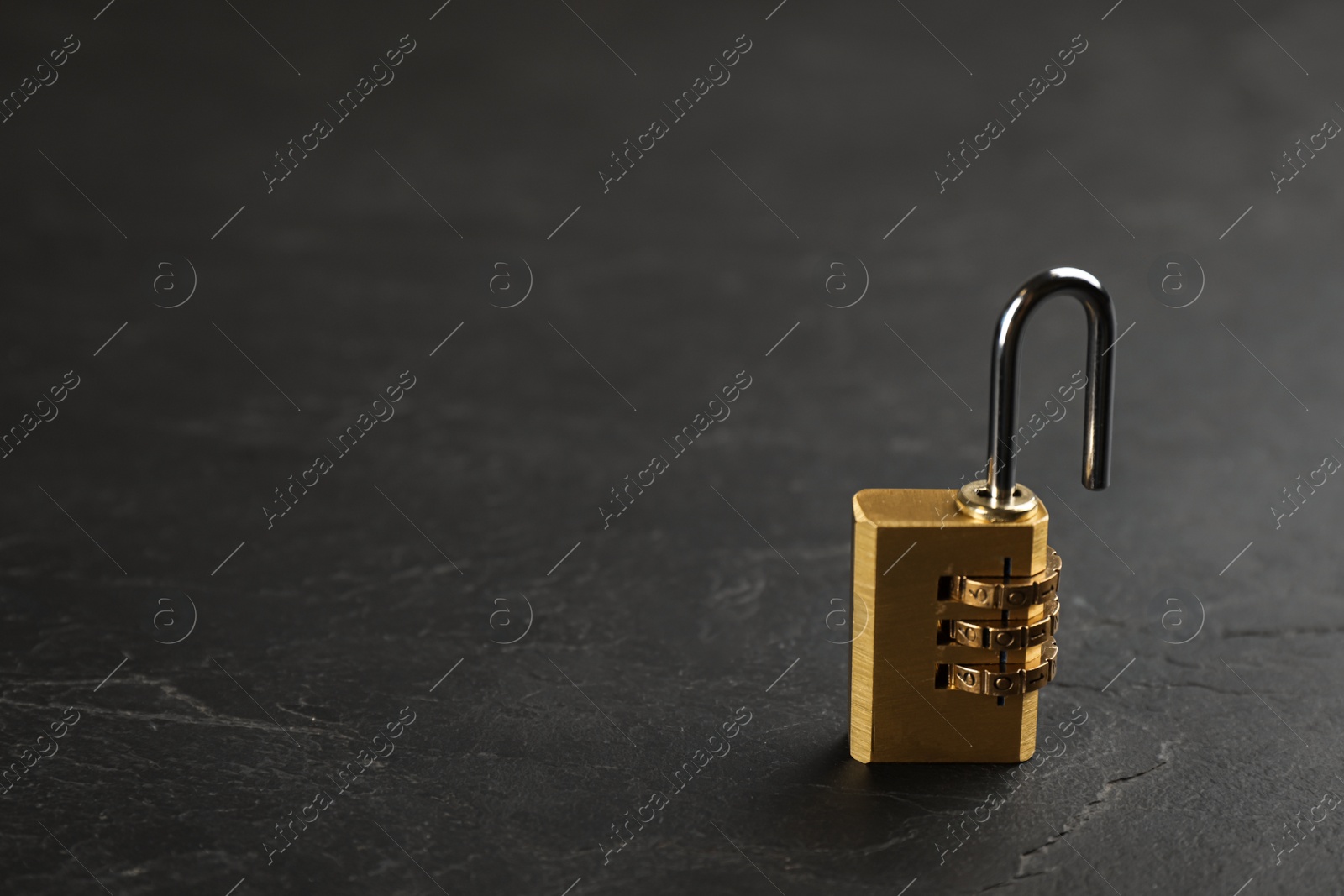 Photo of Modern combination lock on black table. Space for text