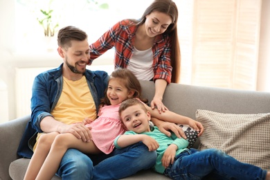 Young couple spending time with children at home. Happy family