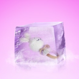 Image of Conservation of genetic material. Baby teether toy in ice cube as cryopreservation on violet background