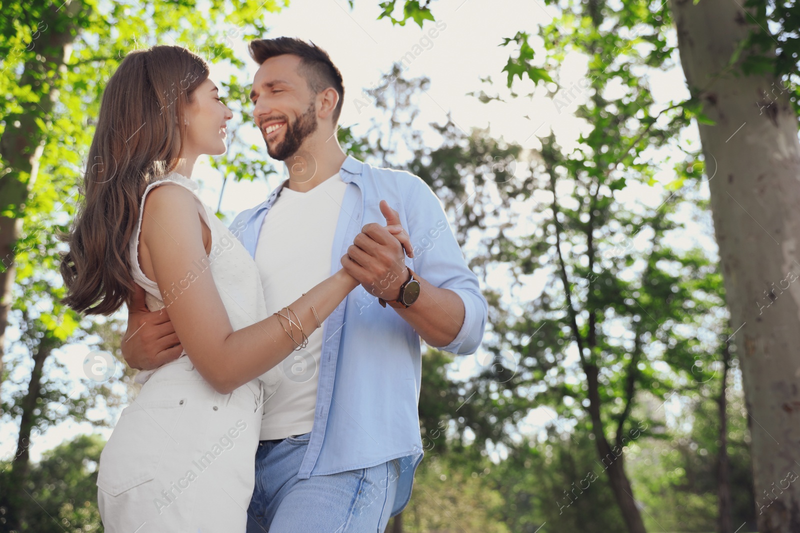 Photo of Lovely young couple dancing together in park on sunny day