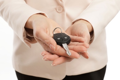 Woman holding car key isolated on white