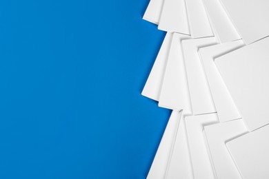 Photo of Many stacks of paper sheets on blue background, flat lay. Space for text