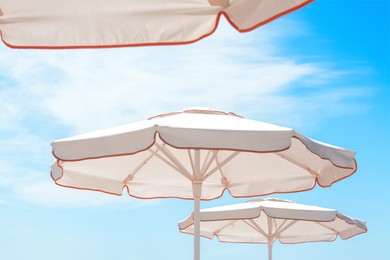 Photo of White beach umbrellas outdoors on sunny day