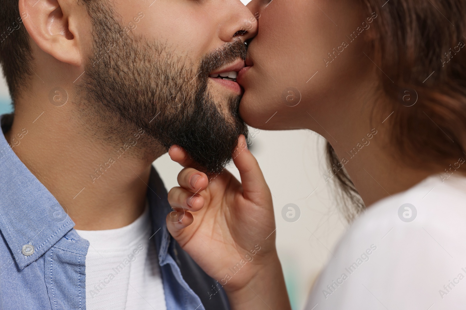 Photo of Love relationship. Passionate young couple kissing on blurred background, closeup