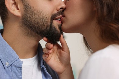 Love relationship. Passionate young couple kissing on blurred background, closeup
