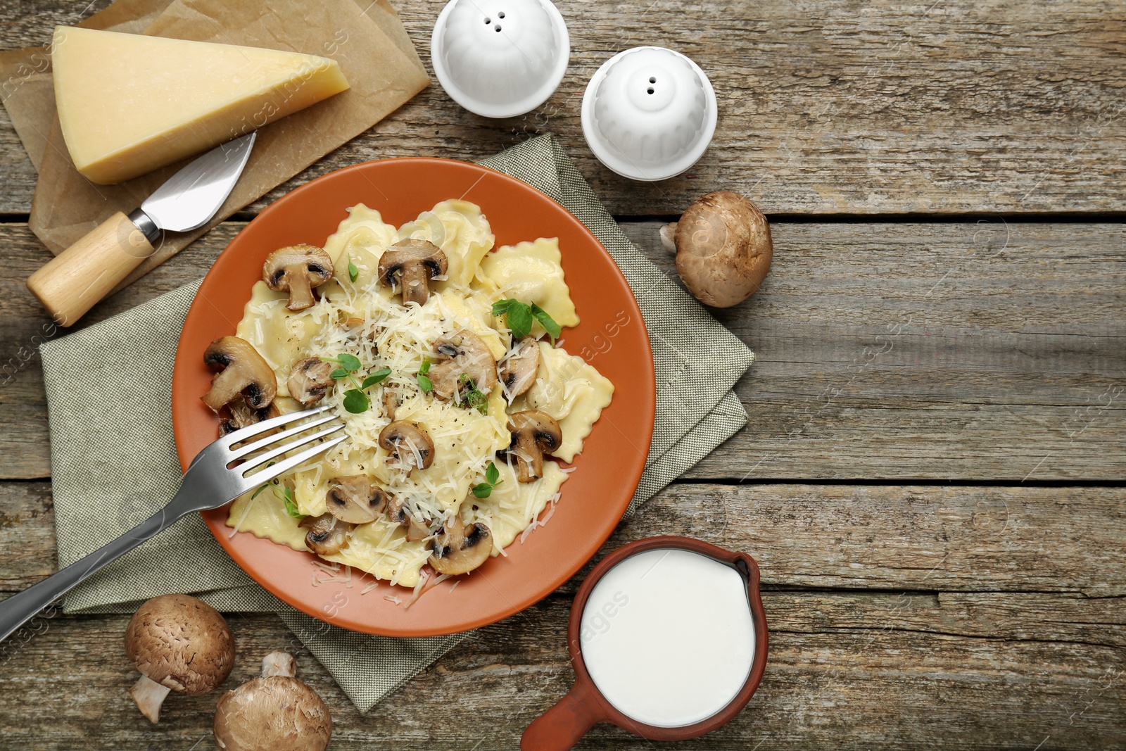 Photo of Delicious ravioli with ingredients on wooden table, flat lay. Space for text