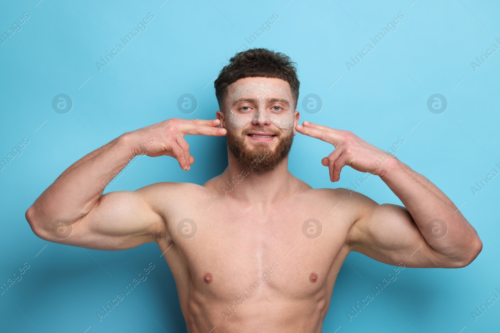 Photo of Handsome man with facial mask on his face against light blue background