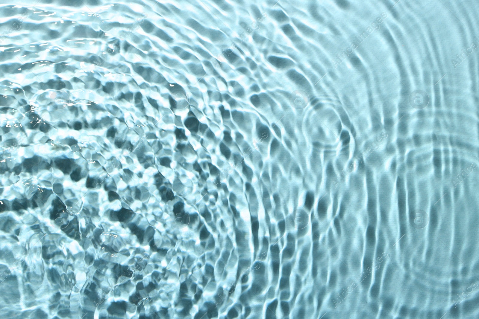 Image of Rippled surface of clear water on light blue background, top view