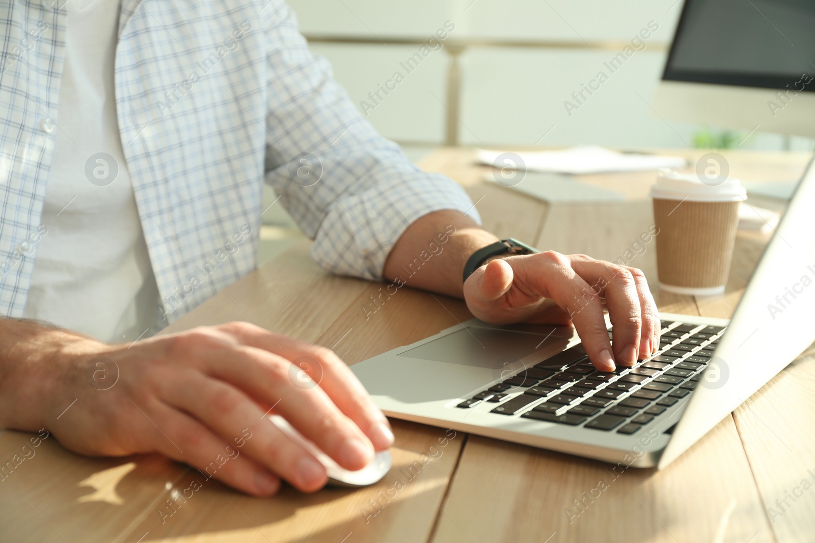 Photo of Freelancer working on laptop at table indoors, closeup