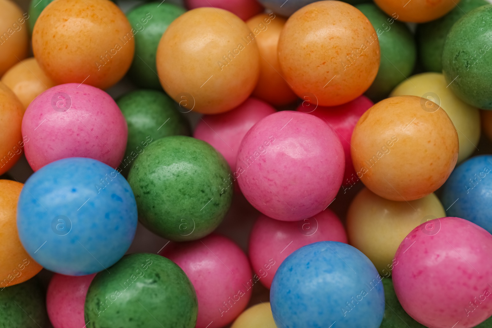 Photo of Many bright chewy gumballs as background, top view