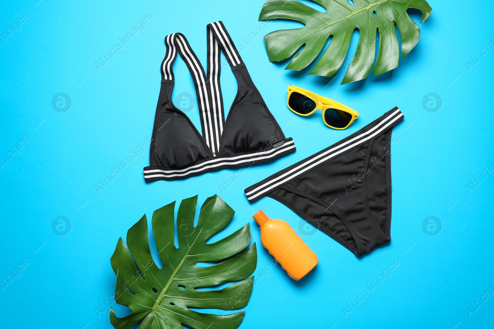 Photo of Flat lay composition with bikini and beach objects on color background