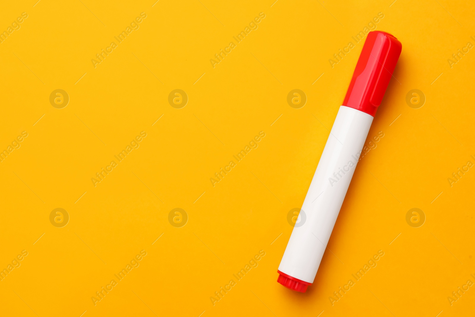 Photo of Bright red marker on orange background, top view. Space for text