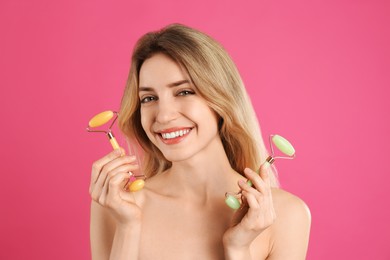 Photo of Young woman with natural face rollers on pink background