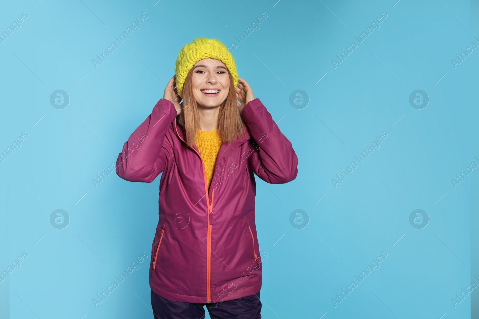 Photo of Young woman wearing warm clothes on color background. Ready for winter vacation