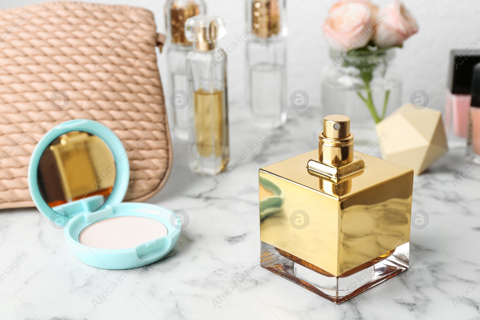 Photo of Bottle of perfume and cosmetics on marble table