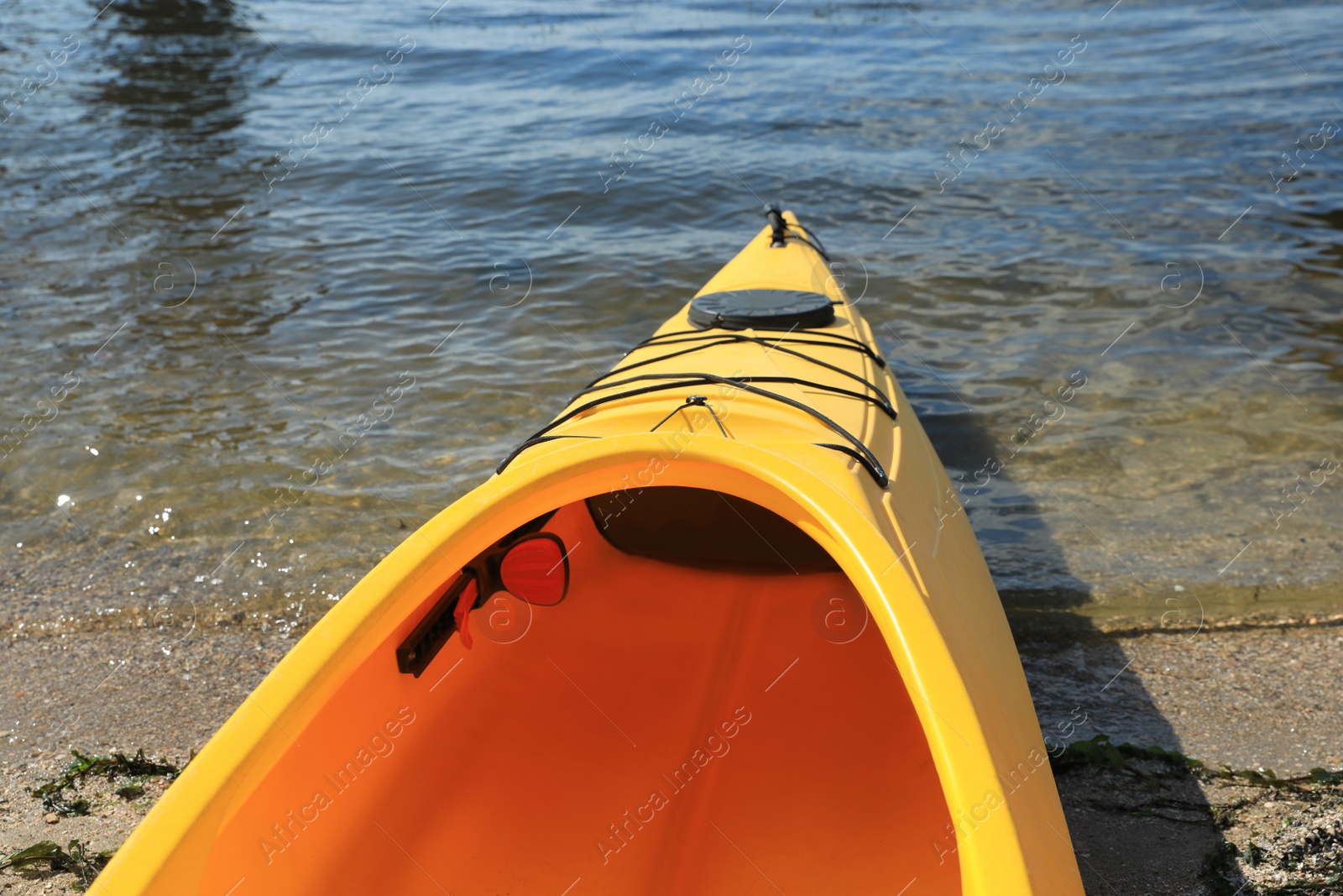 Photo of Yellow kayak on beach near river, closeup. Summer camp activity